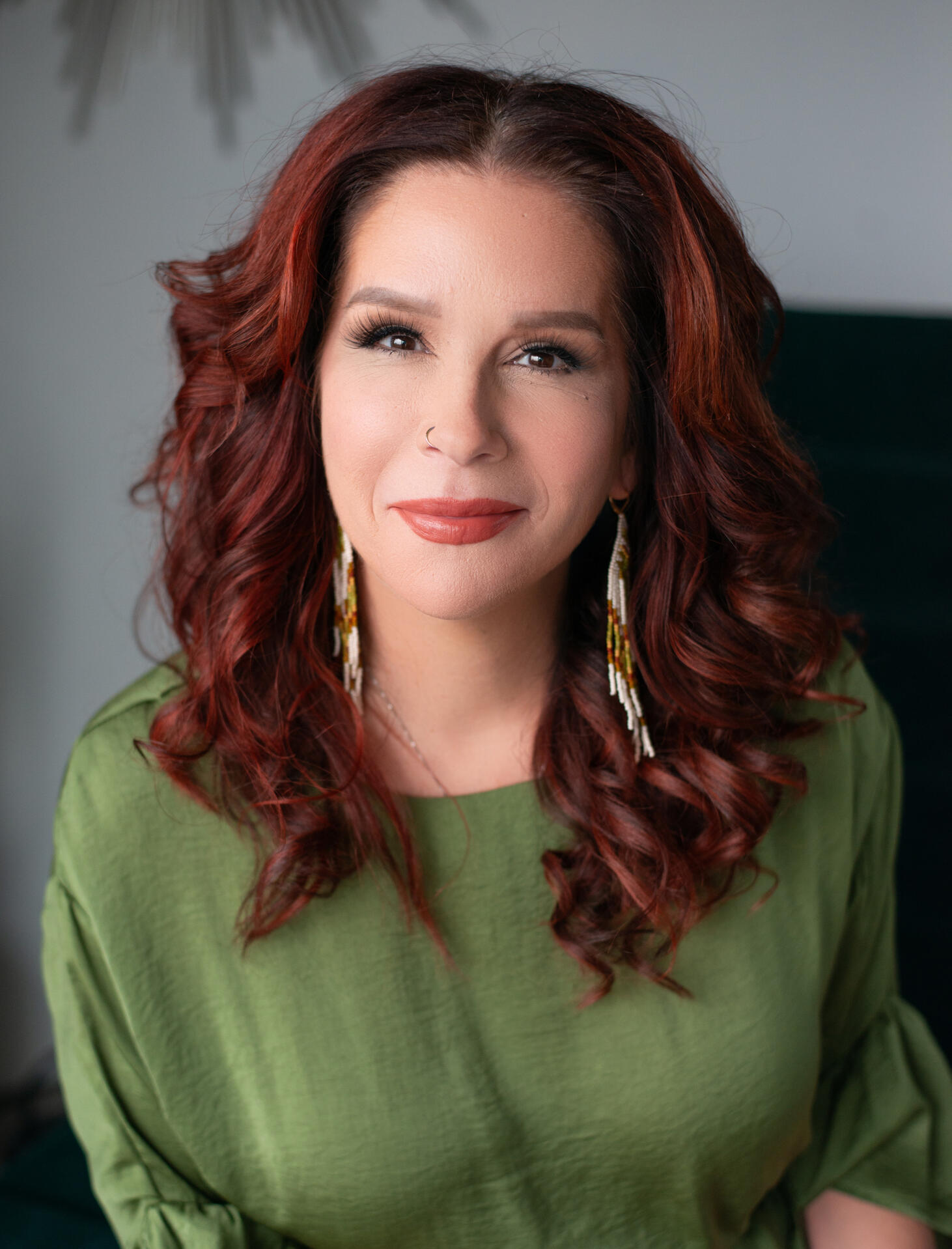 woman in green shirt with red hair smiling